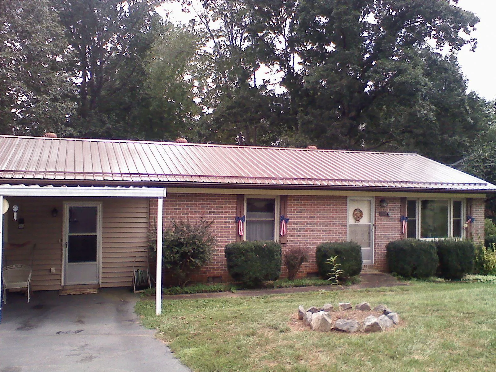 Bronze metal roof and carport on a brick ranch home — Roof Repair work by our crew in Springdale